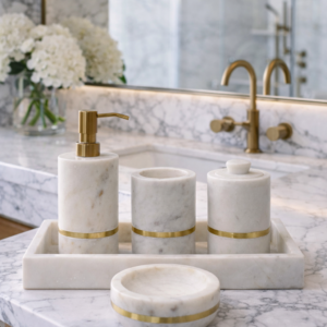 White marble bathroom accessory set with gold accents styled on a luxury marble vanity unit