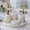 Rounded white marble bathroom accessory set styled on a luxury marble vanity unit