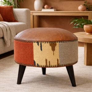 Round patchwork upholstered footstool with leather top styled in a modern living room