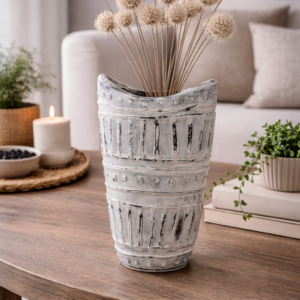 Cream textured ceramic vase with tribal-style detailing placed on a wooden console table in a neutral-toned living room with soft natural lighting