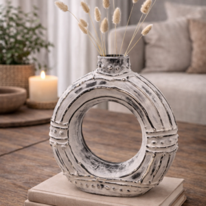 Cream donut shaped ceramic vase with distressed white finish on a neutral background, featuring a modern circular design for contemporary home décor