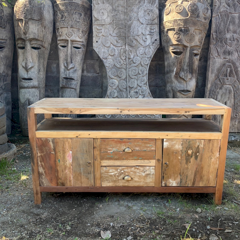 Reclaimed wood sideboard with open shelf, two drawers and two cabinet doors, photographed outdoors in front of carved wooden statues