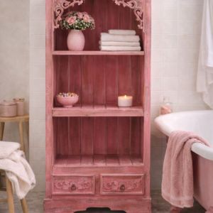 Pinkwash wooden bathroom cabinet with open shelving and carved detailing, styled in a vintage bathroom beside a clawfoot bathtub with soft towels, candles, and neutral tiled walls.