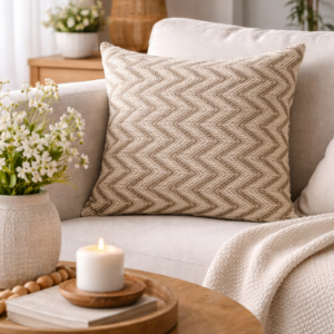 Beige and taupe herringbone cushion styled on a light sofa in a cosy living room, paired with neutral cushions, a wooden coffee table, soft throw, and warm natural light.
