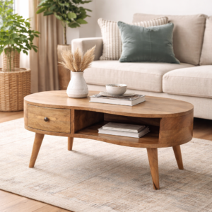 Mid-century oval wooden coffee table with drawer and open shelf styled in a modern neutral living room