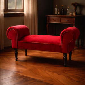 Red velvet window seat with rolled arms and dark wooden legs placed in a warm, classic living room with wooden flooring and natural light from a window.