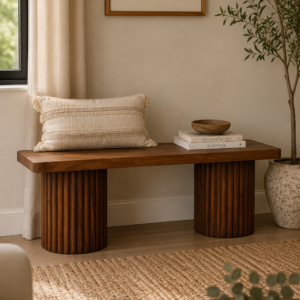 Wooden bench with fluted cylindrical legs and thick top, styled as seating in a contemporary interior